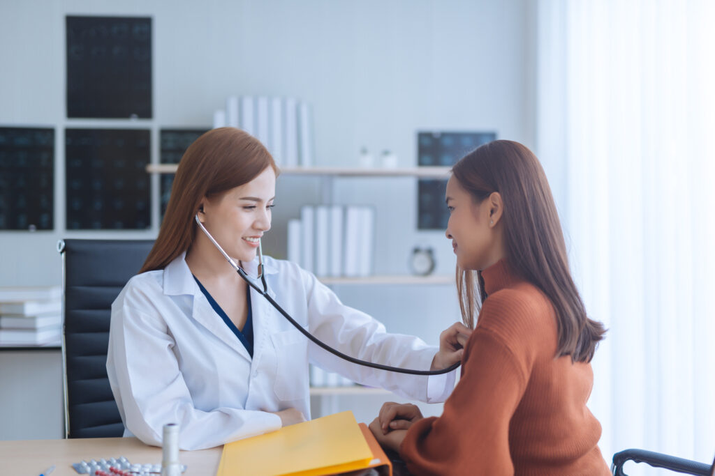 female primary care provider using a stethoscope to listen to a female patient's heart