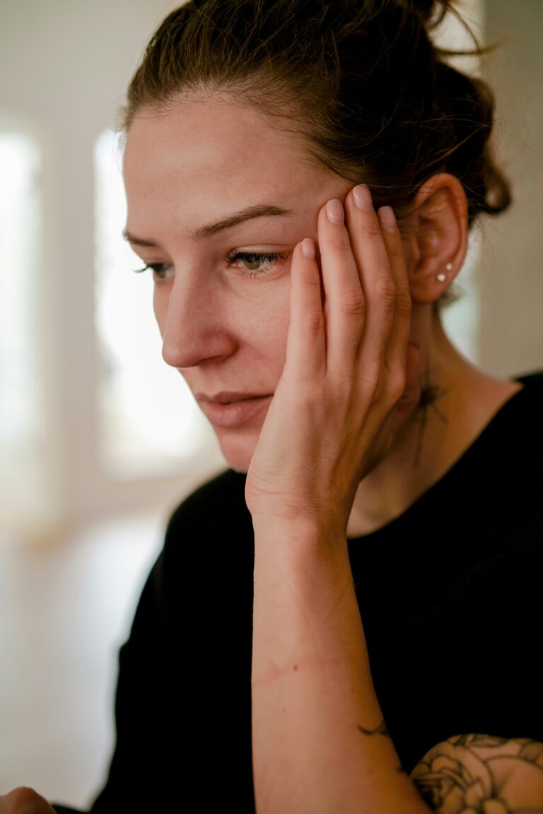 woman with hand on her face, worried, manage stress