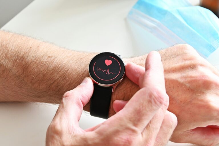 two hands looking at a black watch counting a heartrate and tracking heart health